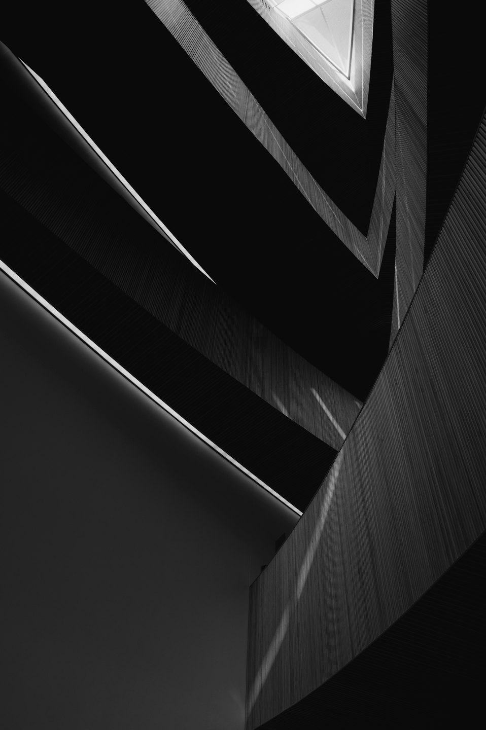Modernes Gebäudesinnere mit geometrischen Linien und Lamellenpaneelen.