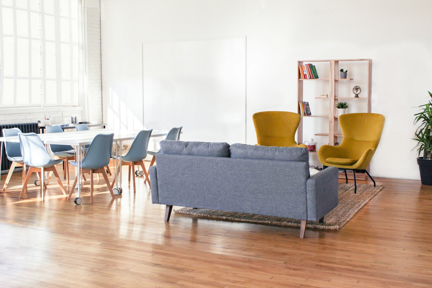 Modernes Büro mit Konferenztisch, Loungebereich und Bücherregal.